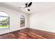 Bright bedroom features striking wood floors, modern ceiling fan, and two arched windows at 17012 N 57Th St, Scottsdale, AZ 85254