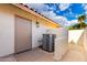 Exterior shot showing the side access door and AC unit under a bright blue sky with scattered clouds at 17012 N 57Th St, Scottsdale, AZ 85254