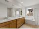 Bright bathroom features wood cabinets, double sink, shower, and tub at 17643 W Rancho Dr, Litchfield Park, AZ 85340