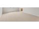Neutral carpeted room shows view into the kitchen with wood cabinets at 17643 W Rancho Dr, Litchfield Park, AZ 85340
