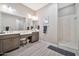 Spacious bathroom with double vanity, vanity chair, and glass door shower at 17913 W Sunward Dr, Goodyear, AZ 85338