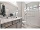 Neutral bathroom featuring a glass shower, dual vanity, and light wood-look flooring at 17913 W Sunward Dr, Goodyear, AZ 85338