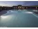 Inviting community pool at dusk with ample seating and stylish umbrellas for a relaxing experience at 17913 W Sunward Dr, Goodyear, AZ 85338