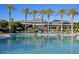 Large community pool with inviting blue water and surrounding palm trees at 17913 W Sunward Dr, Goodyear, AZ 85338