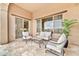 Cozy covered patio with comfortable seating, an outdoor table, and view into the backyard at 17913 W Sunward Dr, Goodyear, AZ 85338