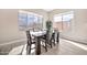The dining room has a wooden table, six chairs, and large windows that let in ample natural light at 17913 W Sunward Dr, Goodyear, AZ 85338
