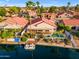 Aerial view of a home with a boat dock, pool, lush landscaping and beautiful lake views at 186 N Starboard Dr, Gilbert, AZ 85234