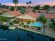 Aerial view of a home with a pool, patio, boat dock, and lush landscaping along a waterway at 186 N Starboard Dr, Gilbert, AZ 85234