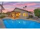 Inviting backyard featuring a sparkling pool, covered patio, and lush landscaping at sunset at 186 N Starboard Dr, Gilbert, AZ 85234