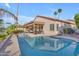 Beautiful backyard with a refreshing swimming pool, covered patio, and tropical palm trees at 186 N Starboard Dr, Gilbert, AZ 85234