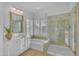 Modern bathroom with dual vanities, soaking tub, glass-enclosed shower, and plantation shutters for natural light at 186 N Starboard Dr, Gilbert, AZ 85234