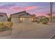 Spacious home featuring a three-car garage, large driveway, and manicured landscaping at sunset at 186 N Starboard Dr, Gilbert, AZ 85234