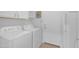 Bright laundry room with white washer, dryer, cabinets, and convenient access to the outside and refrigerator at 186 N Starboard Dr, Gilbert, AZ 85234