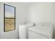 Bright laundry room features a front-loading washing machine and dryer with a window to the exterior at 1918 E Anchor Dr, Gilbert, AZ 85234