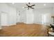 Bright living room with light wood floors, white walls, and ceiling fan at 1918 E Anchor Dr, Gilbert, AZ 85234