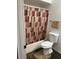Bathroom featuring a standard toilet, bath/shower with curtain, and rustic tile flooring at 19601 N 7Th N St # 1032, Phoenix, AZ 85024