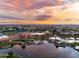 Sunset aerial view of community center overlooking pond and swimming pool surrounded by houses at 20183 N Big Dipper Dr, Maricopa, AZ 85138