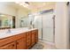 Bright bathroom featuring double sinks, and glass-enclosed shower at 20183 N Big Dipper Dr, Maricopa, AZ 85138
