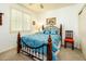 Bedroom with wood-framed bed, window with blinds, and accent chair at 20183 N Big Dipper Dr, Maricopa, AZ 85138