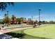Bocce ball court and seating area in front of community center with palm trees and desert landscaping at 20183 N Big Dipper Dr, Maricopa, AZ 85138