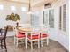 Bright dining area with tile floors, white chairs, a wood table, and decorative wall plates at 20183 N Big Dipper Dr, Maricopa, AZ 85138