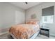 This bedroom features neutral walls, an orange comforter, and a window with shade at 20373 W Coolidge St, Buckeye, AZ 85396