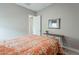 This bedroom features neutral walls, an orange comforter, and access to the bathroom at 20373 W Coolidge St, Buckeye, AZ 85396