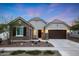Charming home exterior with stone accents, a well-maintained yard, and a welcoming entrance at 20373 W Coolidge St, Buckeye, AZ 85396