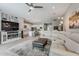 Open-concept living room with a modern entertainment center, large sofa, and seamlessly integrates kitchen at 20373 W Coolidge St, Buckeye, AZ 85396