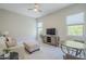 Well-lit living room area with a sofa, seating, television, and light gray walls at 20373 W Coolidge St, Buckeye, AZ 85396