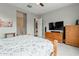 This bedroom features neutral colors, a ceiling fan, and a dresser with a television at 20373 W Coolidge St, Buckeye, AZ 85396