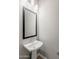 The powder room features a pedestal sink, a framed mirror, and modern lighting at 20373 W Coolidge St, Buckeye, AZ 85396