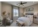 Comfortable bedroom with a ceiling fan, window, cozy chair, and a king bed at 20445 W Rovey Ave, Buckeye, AZ 85396