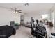 A large bedroom with carpet, fan, an office nook, lounge chair, and an exterior view through the window at 22787 W Gardenia Dr, Buckeye, AZ 85326