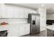 Modern kitchen with white cabinets, stainless steel refrigerator, plenty of counterspace, and hardwood-style flooring at 22787 W Gardenia Dr, Buckeye, AZ 85326