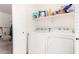Bright laundry room with washer, dryer, and storage shelves at 22787 W Gardenia Dr, Buckeye, AZ 85326