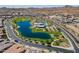 Scenic aerial view of a community with a large lake, pool, clubhouse, and green spaces at 23020 E Excelsior Ave, Queen Creek, AZ 85142