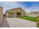 A well-maintained backyard featuring gravel, artificial grass, and a covered patio with a view of the house exterior at 23020 E Excelsior Ave, Queen Creek, AZ 85142