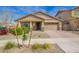 Inviting home exterior featuring a paved driveway, lovely landscaping, and a warm, welcoming facade at 23020 E Excelsior Ave, Queen Creek, AZ 85142