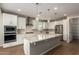 Modern kitchen features white cabinets, stainless steel appliances, and a large center island at 23020 E Excelsior Ave, Queen Creek, AZ 85142