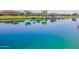 Scenic view of a community pond with lush landscaping and reflections of nearby homes at 23020 E Excelsior Ave, Queen Creek, AZ 85142