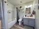Cozy bathroom with shower-tub combo, wood-look floor, and well-lit vanity at 2329 E Juanita Ave, Mesa, AZ 85204