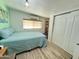 Bright bedroom with wooden floors featuring a cozy bed, natural light and a bookcase at 2329 E Juanita Ave, Mesa, AZ 85204