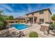 Spacious backyard with a pristine pool, covered patio, built-in grill, and serene landscaping at 26011 W Tonopah Dr, Buckeye, AZ 85396