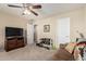 Bedroom with ceiling fan, sofa, television, weights, and two doors at 26011 W Tonopah Dr, Buckeye, AZ 85396