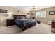 Spacious primary bedroom with a ceiling fan, bedside tables, and a large window at 26011 W Tonopah Dr, Buckeye, AZ 85396