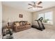 Bedroom includes a ceiling fan, sofa, exercise equipment, and a bright window at 26011 W Tonopah Dr, Buckeye, AZ 85396