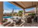 Inviting covered patio with comfortable seating, overlooking the sparkling pool and landscaped backyard at 26011 W Tonopah Dr, Buckeye, AZ 85396