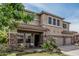 Charming two-story home with a covered front porch and stone accents at 26011 W Tonopah Dr, Buckeye, AZ 85396