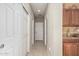 Long hallway with multiple doors, tile floor, and wood cabinets at 26011 W Tonopah Dr, Buckeye, AZ 85396